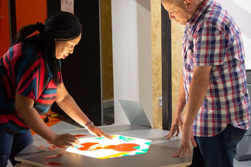 two people doing an activity at a lightbox